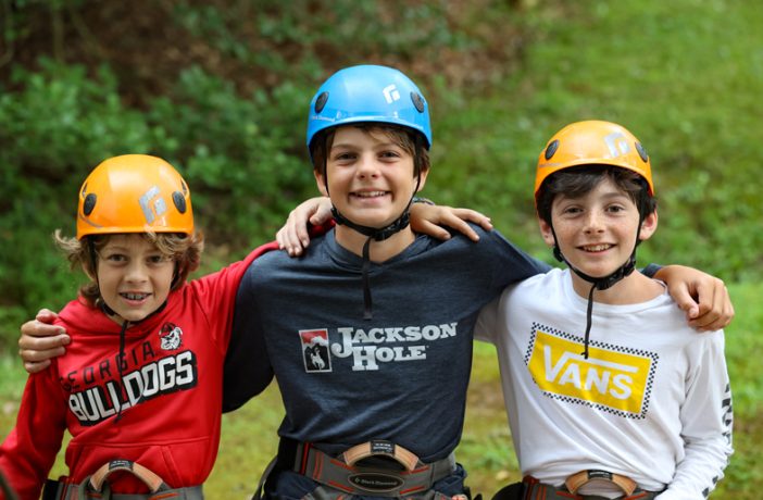 three campers sitting at rock climbing